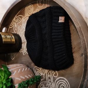 Black knit winter beanie with top ponytail hole.